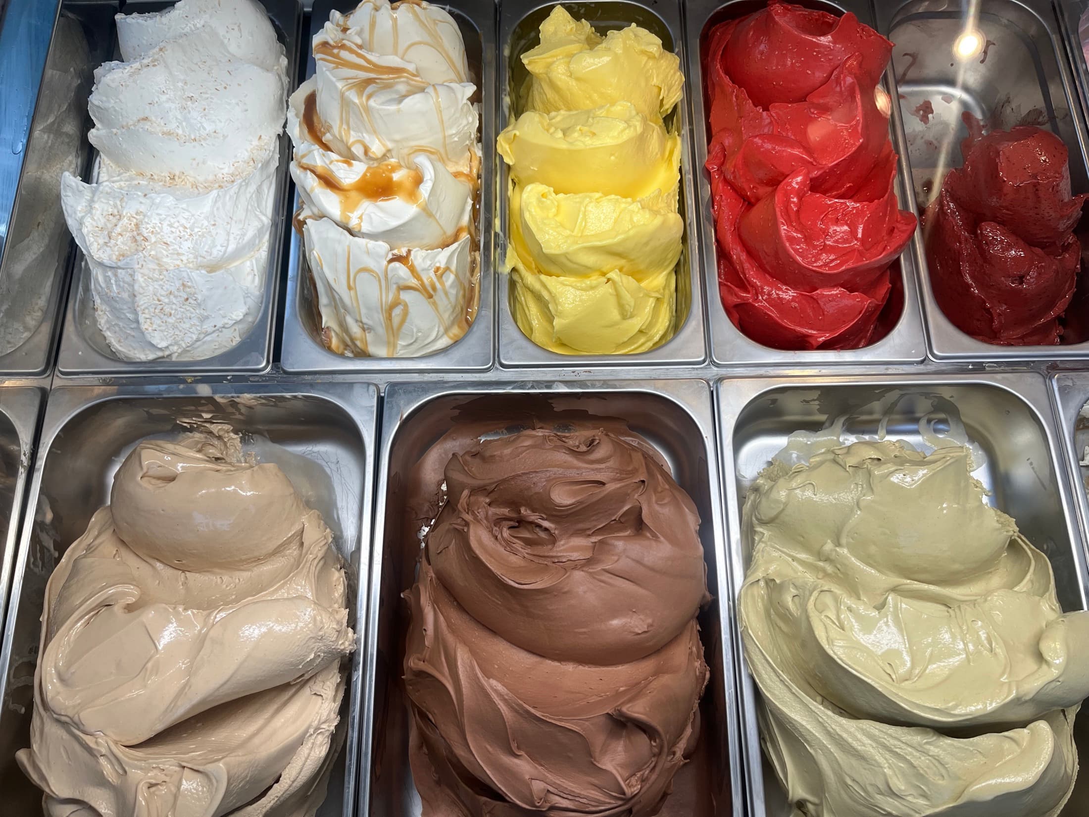 Kantiner med gelato staplade i frys