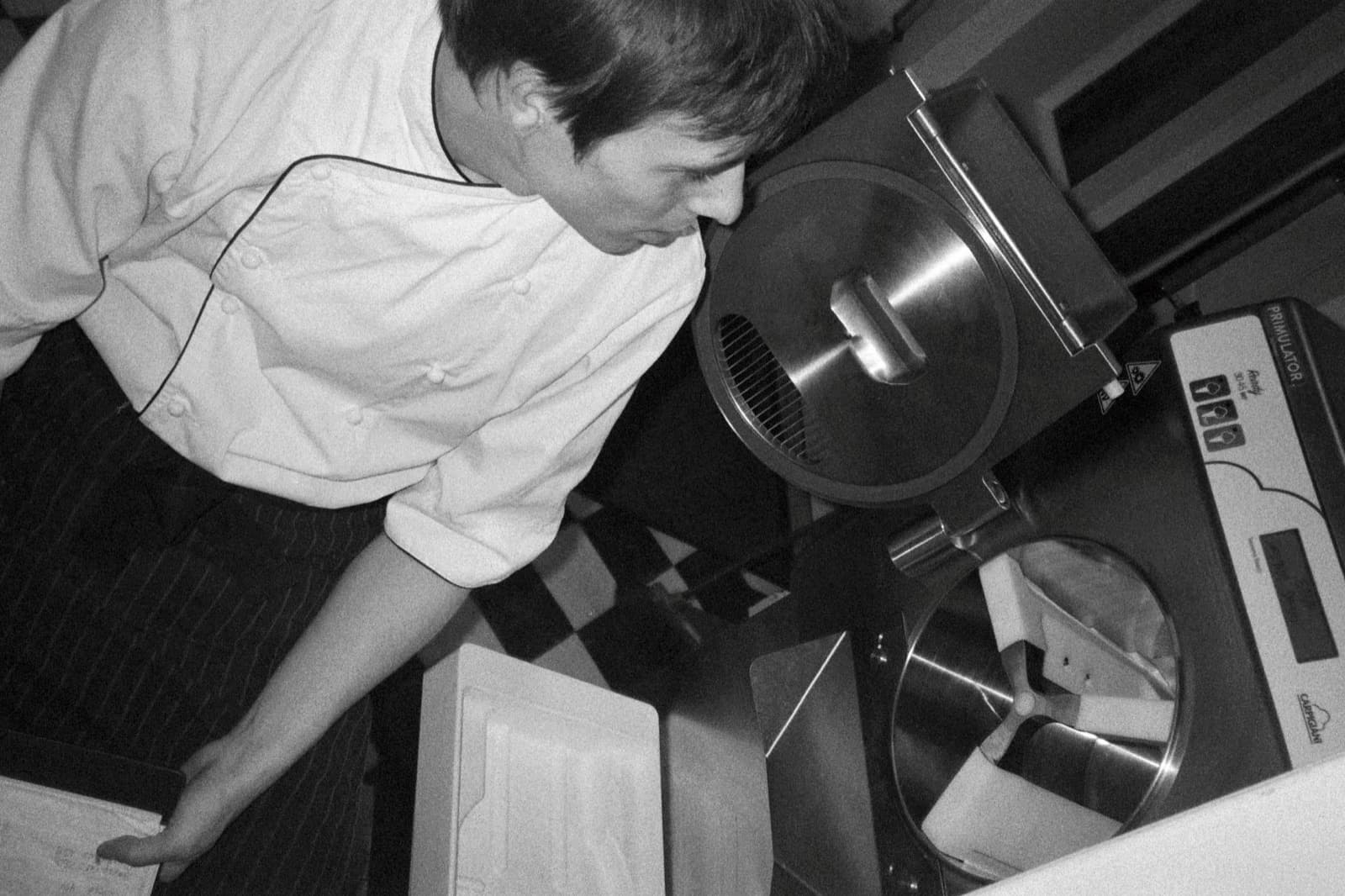 Gelatomakare fyller en kantin vid glassmaskinen i produktionsköket